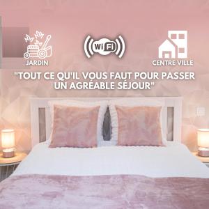 a bedroom with a white bed with pink pillows at Appartement rénové - wifi - jardin - centre de Niort in Niort