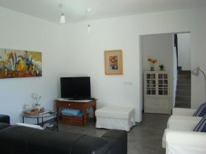 a living room with a couch and a tv at Casa Aina in Cala Bona