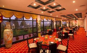 a restaurant with tables and chairs and a large window at Gem Park Ooty in Ooty