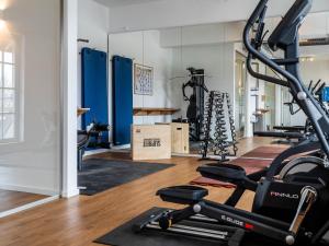 a gym with several treadmills and a treadmill at Reetland am Meer - Premium Reetdachvilla mit 2 Schlafzimmern, Sauna und Kamin E04 in Dranske