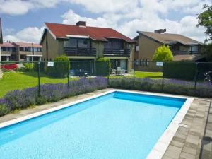 ein blauer Pool vor einem Haus in der Unterkunft Wijk de Brabander 142 in Cadzand