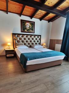 a large bedroom with a large bed with blue sheets at Makaza Complex in Momchilgrad