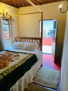 - une chambre avec un lit et une porte donnant sur une terrasse dans l'établissement Mrefu Eco-lodge, à Marangu