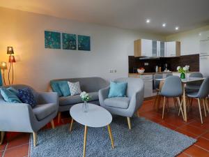 un salon avec des canapés et une table ainsi qu'une cuisine dans l'établissement Feriendorf Rugana - Klassik Ferienwohnung mit 2 Schlafzimmern und 2 Terrassen D55, à Dranske