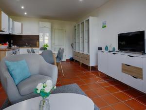 un salon avec un canapé, une table et une télévision dans l'établissement Feriendorf Rugana - Klassik Ferienwohnung mit 2 Schlafzimmern und 2 Terrassen D55, à Dranske