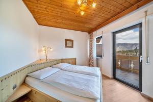 1 dormitorio con cama y ventana grande en Residence Kronstein - Fewo 9, en Tesimo