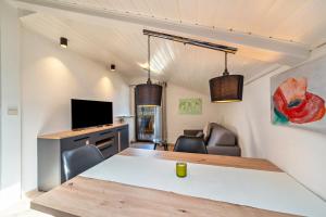 Habitación con mesa, TV y sofá. en Residence Kronstein - Fewo 9, en Tesimo