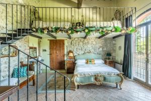 a bedroom with a bed and a stone wall at Villa Unica Sant'Alberto in Campiglia dʼOrcia