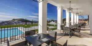 a balcony with tables and chairs and a pool at Barceló Aracena & Spa in Aracena