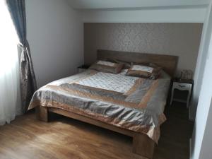a bedroom with a large bed with two pillows on it at Apartments Mona Lisa in Raslina