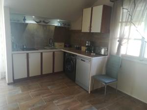 a kitchen with a washing machine and a chair at Apartments Mona Lisa in Raslina