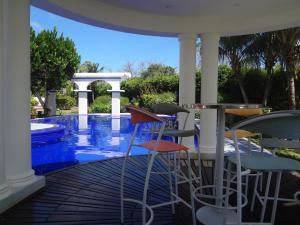 un patio avec une table et des chaises à côté d'une piscine dans l'établissement Posada Boutique South Beach, à San Andrés
