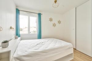 een witte slaapkamer met een bed en een raam bij Vacances et detente a la Tranche-sur-Mer in La Tranche-sur-Mer