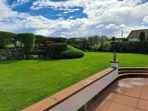 a garden with a green lawn and a wall at Lecale Bliss in Downpatrick