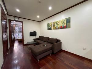 a living room with a couch and a tv at NINE HOUSING Truc Bach in Hanoi