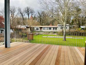 una terraza de madera con una valla y un patio en Putbus Ferienwohnung Kleine Auszeit, en Putbus