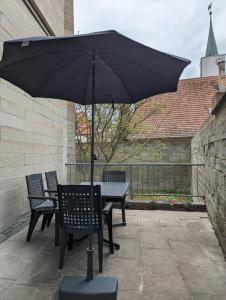 einen Tisch und Stühle mit Sonnenschirm auf einer Terrasse in der Unterkunft Im Alten Gefängnis in Überlingen