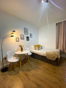 1 dormitorio con 1 cama y 1 mesa con sillas en Holland Road Stays, en Londres