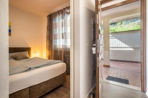 um quarto com uma cama e uma porta de vidro deslizante em Suite Perlago em Tignale
