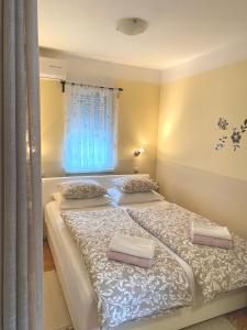 two twin beds in a room with a window at Apartman Lucija in Gradići