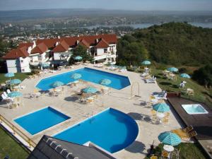 an overhead view of a pool with chairs and umbrellas at Le Mirage Village Club Resort in Villa Carlos Paz