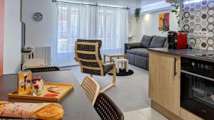 a kitchen and living room with a couch and a table at Suite Fidji in Luxeuil-les-Bains