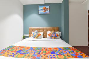 a bedroom with a bed with a colorful comforter at FabHotel Nidhivan, Udhna Junction in Surat