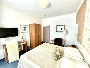 - une chambre avec un lit, un bureau et une télévision dans l'établissement Hotel Saarburger Hof, à Sarrebourg