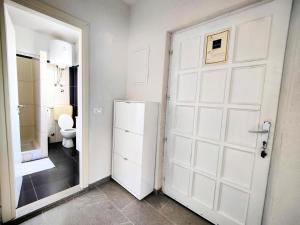a bathroom with a white door and a toilet at Apartments Dajana in Orebić +19 photos