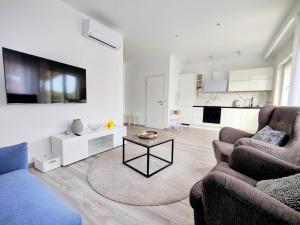 a living room with two couches and a tv at Apartments Dajana in Orebić