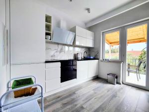 a kitchen with white cabinets and a black oven at Apartments Dajana in Orebić