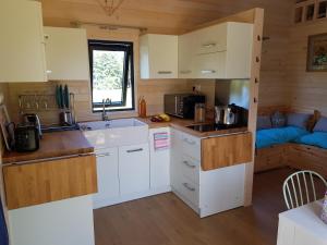 a small kitchen with white cabinets and a sink at Le Domaine Des Anges, écolodge in Thenay