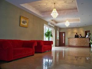 a living room with a red couch and a bar at Hotel Gniecki Gdansk in Przejazdowo