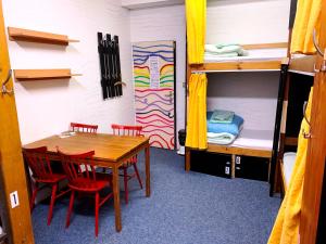 a dining room with a table and chairs and bunk beds at Hostel KlonDike in Pec pod Sněžkou