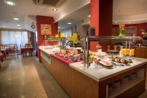 a buffet line in a restaurant with food at Hotel Acacias Suites & Spa in Lloret de Mar
