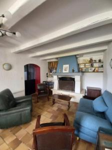 Elle comprend un salon doté d'un mobilier bleu et d'une cheminée. dans l'établissement Villa Oleronaise, au Château-dʼOléron