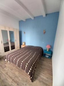 - une chambre avec un lit et un mur bleu dans l'établissement Villa Oleronaise, au Château-dʼOléron