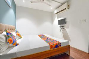 1 dormitorio pequeño con 1 cama y TV en FabHotel Nidhivan, Udhna Junction, en Surat