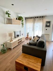 a living room with a couch and a tv at Apartamento completo Gijón in Gijón