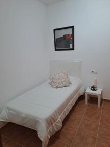 een bed in een witte kamer met een tafel bij Apartamento en Fuengirola junto al paseo marítimo in Fuengirola