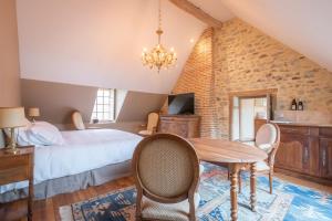 - une chambre avec un lit, une table et des chaises dans l'établissement Domaine de Charnay Villégiature Sologne, à Vierzon