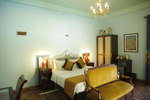 um quarto com uma cama, uma cadeira e um lustre em villa pantano em Balapitiya