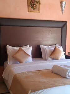 a large bed with white pillows on top of it at kasbah Dar Bahnini in Skoura