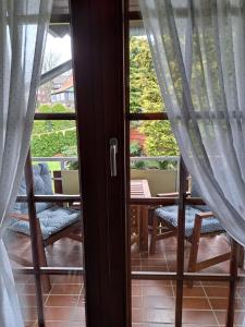 una puerta a un balcón con mesa y sillas en Harzzeit, en Hahnenklee-Bockswiese