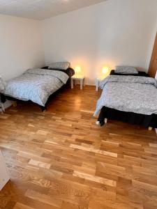 Pokój z 2 łóżkami i drewnianą podłogą w obiekcie HBA Appartsments w Malmö