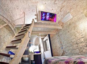 a room with a staircase and a tv on the wall at l'angolo di Gaudì, alcoba Fascinosa in Putignano