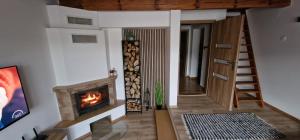 a living room with a fireplace and a staircase at Chata Family s vírivkou v Slovenskom raji in Spišská Nová Ves