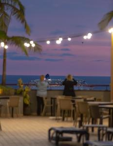 duas pessoas de pé numa varanda com vista para o oceano em The Views Monumental em Funchal