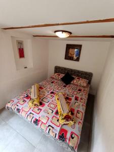 a small bedroom with a bed with a colorful bedspread at Kamp Vrbnica in Plužine