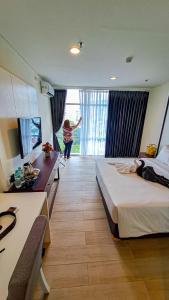a woman is standing in a hotel room at Zia Sanno Menteng Residences- Jakarta in Jakarta
